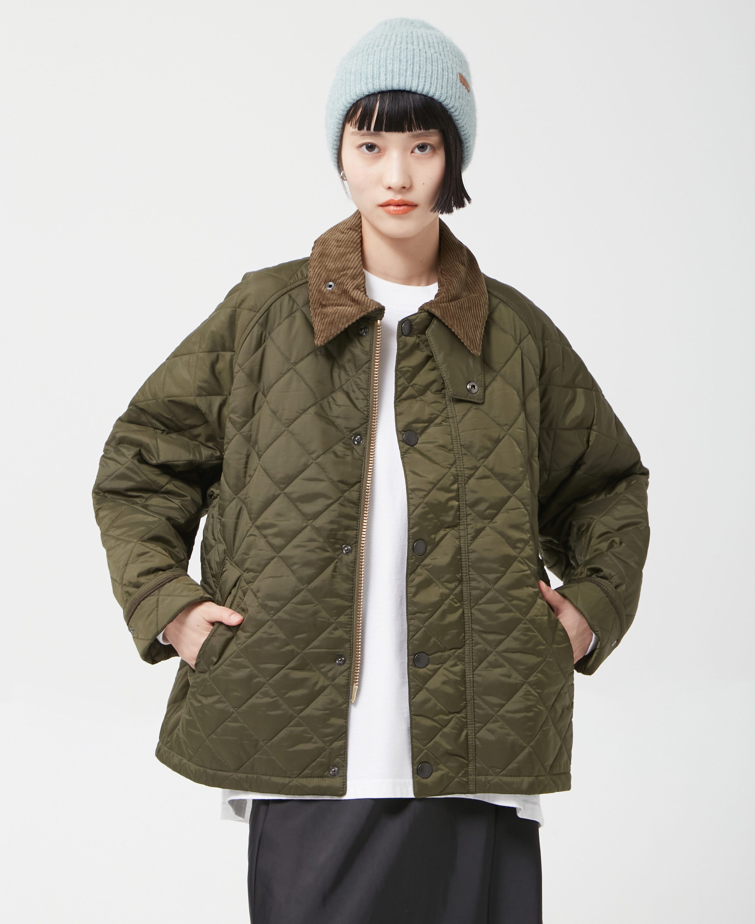 カーキのジャケット・グレーのニット帽・ホワイトのインナーを着用した女性