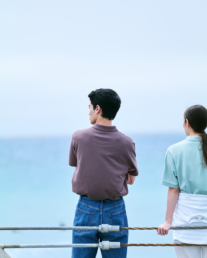 海辺で女性と男性が黄昏ている画像